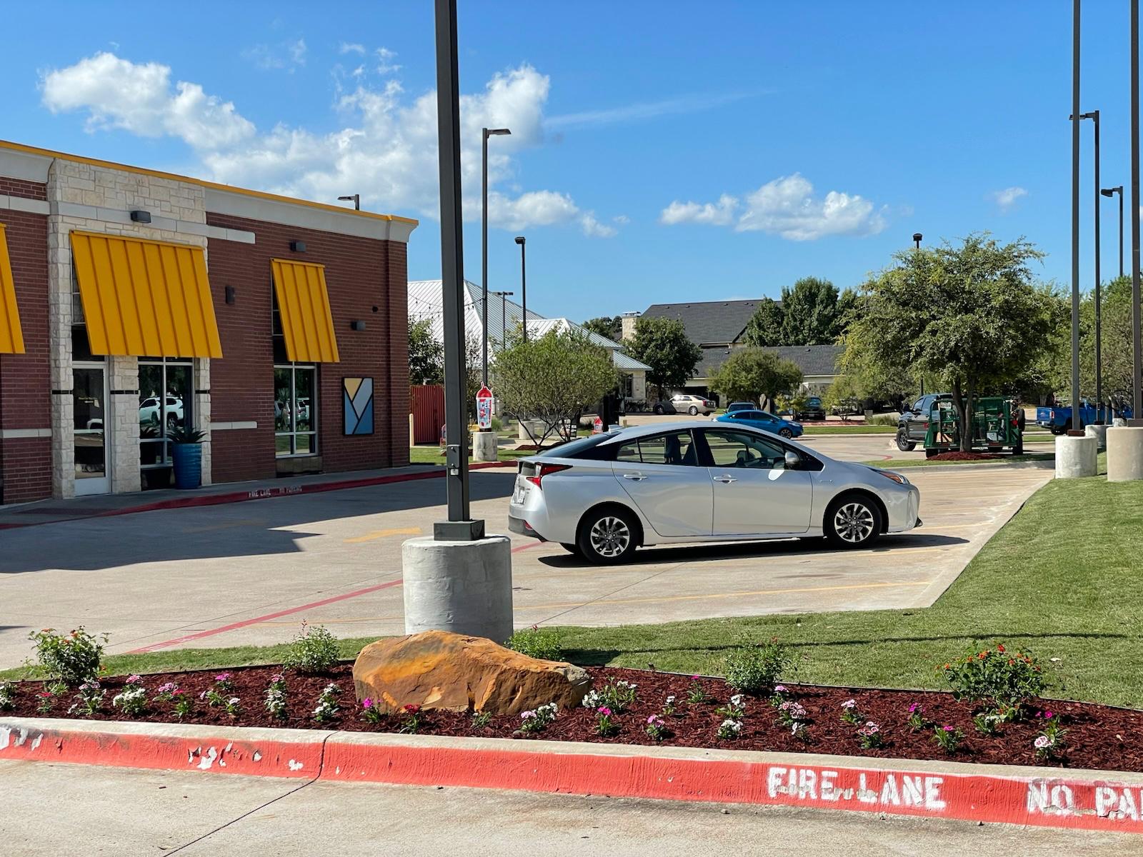Maintained commercial storefront with clean turf and landscaped flower beds